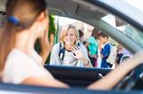 Smiling Caucasian schoolboy waving goodbye to his mother before school-young-drivers